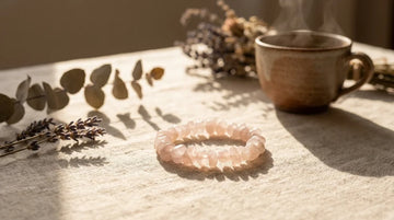 Handcrafted natural rose quartz bracelet on a neutral linen background with soft holiday morning light