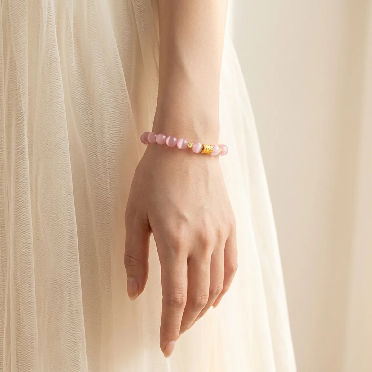 Bracelet en perles d’œil-de-chat rose avec breloque